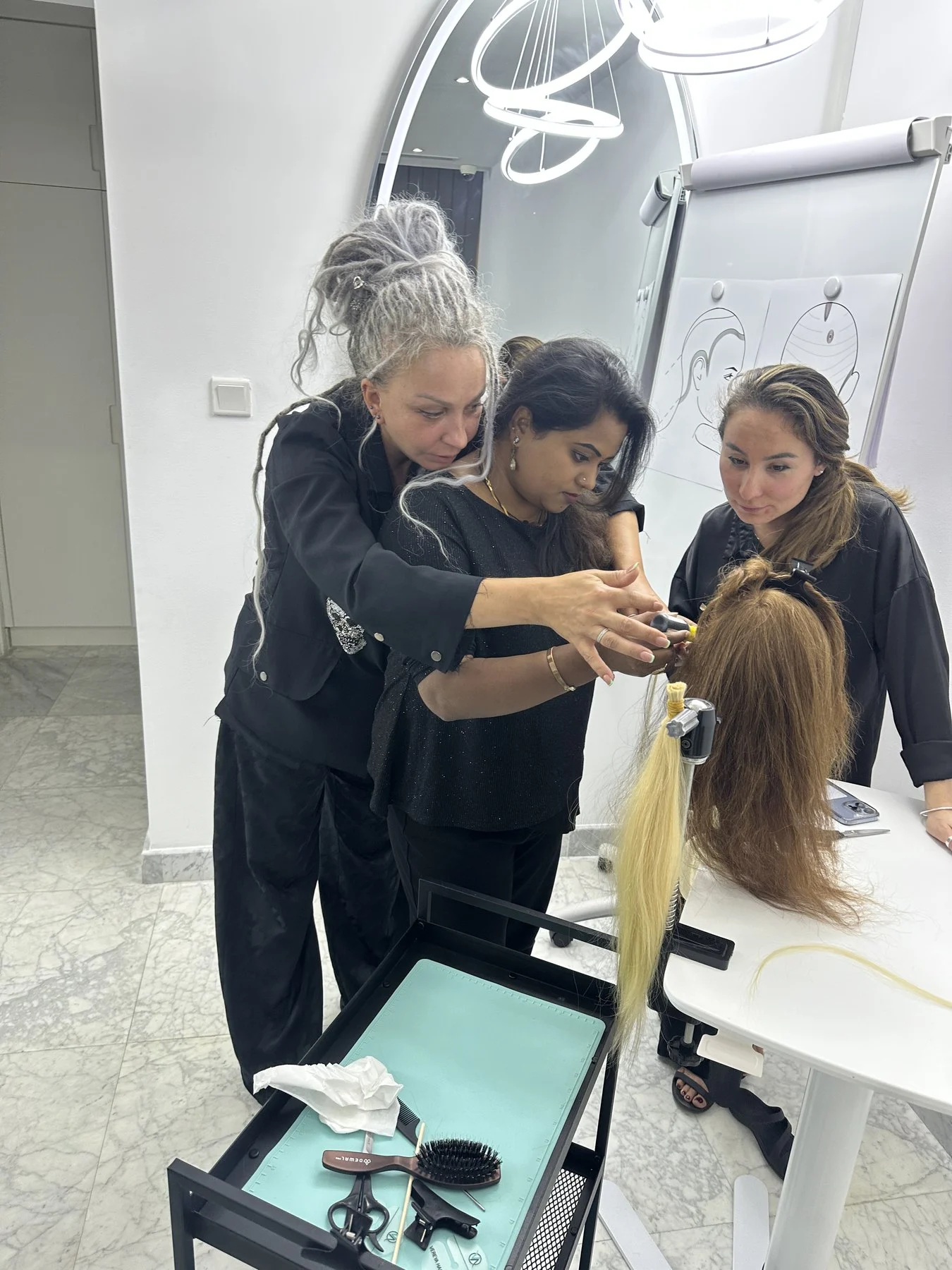 Stylette team members learning a hair extension technique